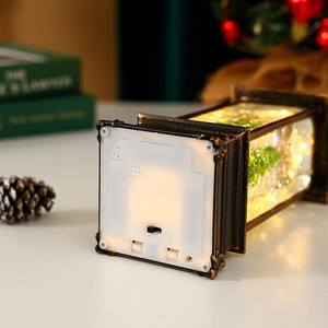 Detail view of the bronze Christmas lantern base showing battery compartment and power switch
