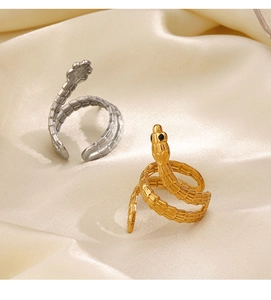 Detailed view of snake rings in gold and silver finish on elegant silk background