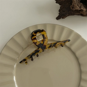 Macro shot of large tortoise shell hair claw clip on a decorative ceramic plate
