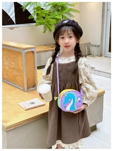 Détail d'un petit sac bandoulière licorne violette pour enfant porté dans un café en plein air