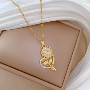 Macro shot of gold sunflower heart necklace with sparkling zircons on satin display