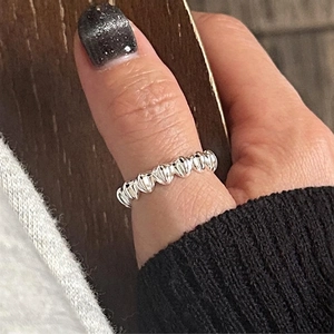 Minimalist 925 sterling silver shell textured ring worn on thumb with wavy scalloped edges