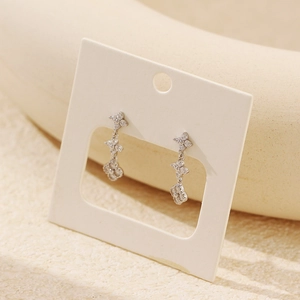 Macro shot of silver tiered clover earrings featuring sparkling cubic zirconia stones