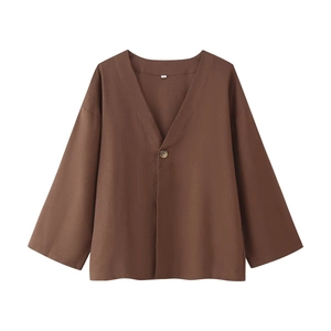 Detailed close-up of dark brown V-neck linen shirt with single-breasted button closure
