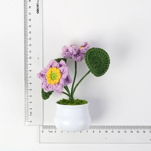 Detailansicht der handgefertigten lila Häkel-Lotusblume im Topf mit Maßstab-Lineal