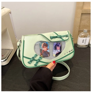 Detail of light green ita bag with heart-shaped window, frog button and anime cards
