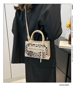 Detalle de bolso de leopardo moderno con herrajes metálicos sobre una elegante chaqueta