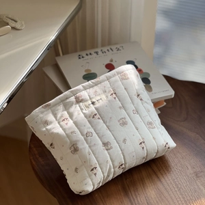 Detail of quilted cotton pouch with animal prints and simple wish woven label