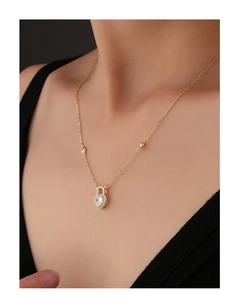 Detail of a gold heart lock pendant with a large heart-cut zircon and pave crystals