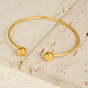 Macro view of 18K gold plated stainless steel open bangle with bead ends on stone