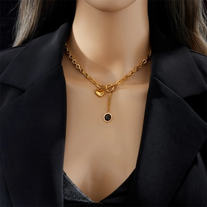 Chunky gold titanium chain necklace featuring heart pendant and OT buckle on model