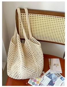 Detail of hollow woven cotton mesh pattern on a beige beach shoulder bag