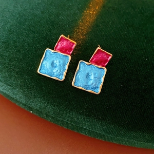 Macro shot of geometric double square earrings with pink and blue textured glaze finish