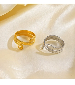 Macro detail of gold and silver snake rings with intricate scale textures on silk