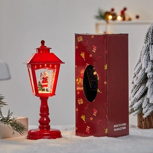 Retro Christmas lantern snow globe with Santa and Xmas tree in a festive red gift box