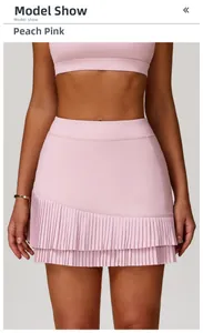 Detail of peach pink pleated sports skirt with double-layer irregular hem and high waist