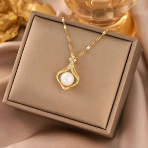 Close-up of gold 18k titanium necklace with pearl pendant and diamonds on a luxury box