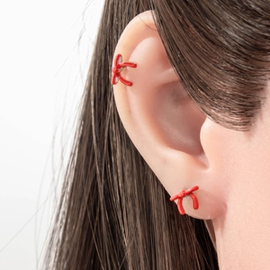 Elegantes rotes Schleifen-Ohrstecker- und Ohrmanschetten-Set am Ohr getragen