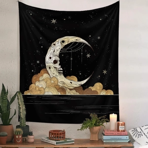 Detail of gothic tapestry with skull moon and golden clouds on black fabric for home decor