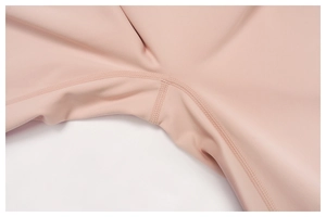 Detail of reinforced four-needle six-thread stitching on pink high-waist yoga pants