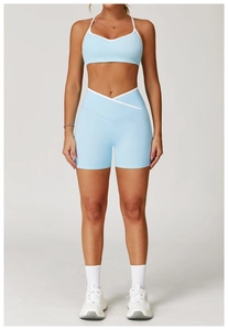 Detail van de yoga short met hoge taille, crossover design en witte contrast biesjes
