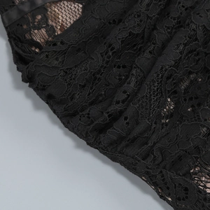 Détail de la dentelle florale noire et de la doublure en maille beige sur la robe corset