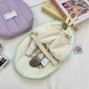 Detail view of mint green shell makeup bag with inner pockets and elastic straps