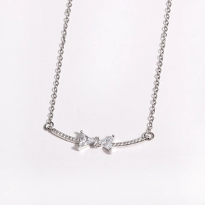 Detail of silver bow pendant with cubic zirconia on a delicate stainless steel chain