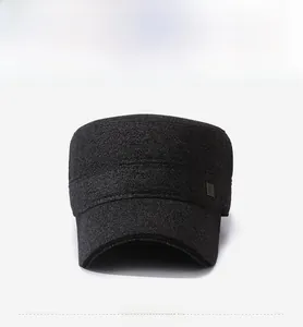 Dettaglio di un cappello piatto in lana grigio scuro con decorazione laterale in metallo