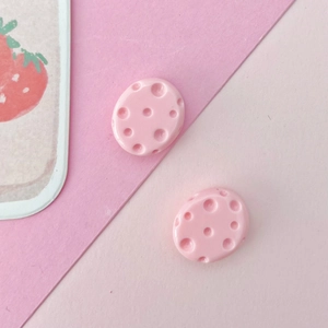 Detail showing two pink oval resin charms with pitted texture for DIY jewelry craft