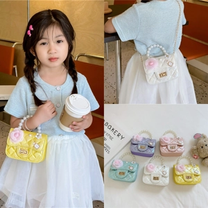 Detail showing five colors of mini pearl handle bucket bags with floral charms and gold locks