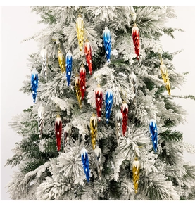 Dettaglio di pendenti a spirale colorati con punte innevate su un albero di Natale