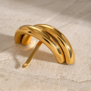 Dettaglio di un fermaglio per capelli in metallo dorato minimalista su fondo in pietra
