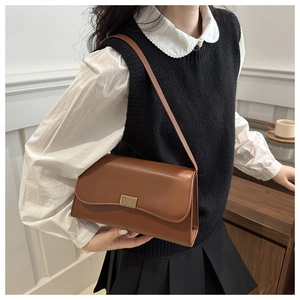 Brown rectangular leather shoulder bag with a gold metal lock shown on a female model