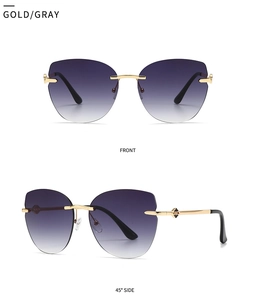 Close-up of rimless cat eye sunglasses with gold metal frame and gray gradient lenses