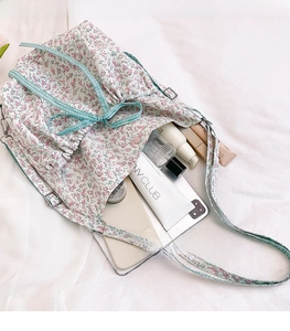 Interior storage view of a floral crossbody bag with makeup and smartphone essentials
