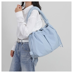 Detail of light blue padded tote bag with drawstring and thick shoulder strap