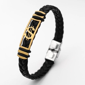 Detail of black braided leather bracelet with gold dollar sign metal plate and silver clasp