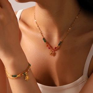 Detail of 18K gold plated sun pendant necklace and matching natural stone beaded bracelet