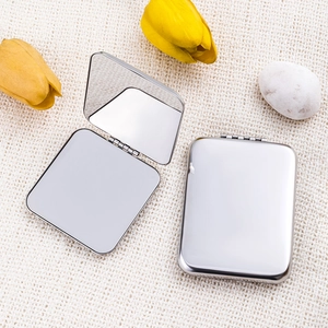 Portable square stainless steel folding makeup mirrors on a beige woven background
