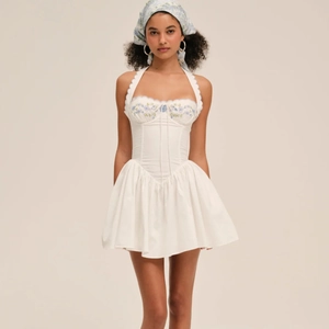 White halter neck mini dress with blue floral embroidery and matching bandana