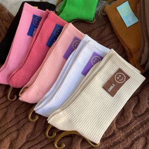 Chaussettes en coton colorées avec patch sourire en noir, rose, blanc et vert
