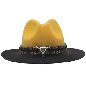 Detail of felt fedora with yellow crown, black brim, ethnic ribbon, and bull skull charm