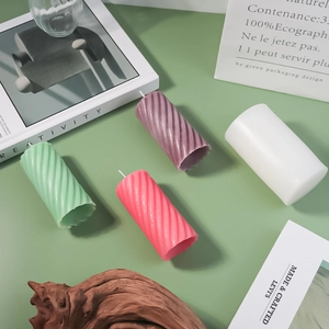 Detailed view of spiral texture on colorful cylindrical candles and silicone molds