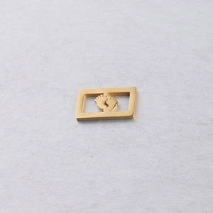 Vue macro du pendentif rectangulaire doré avec motif de empreinte de bébé ajouré