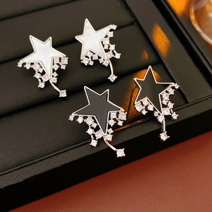Detail of star-shaped stud earrings with shell inlay and sparkling zircon tassels