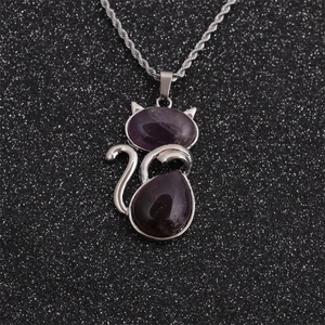 Detail of silver cat pendant necklace with purple amethyst stones on black glitter background