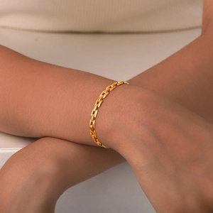 Detail of gold polished strap chain necklace on model neck with rectangular flat links
