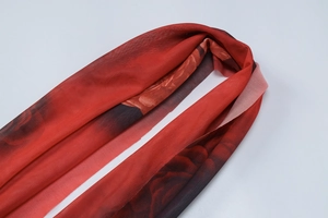 Dettaglio della stampa floreale rossa su chiffon semitrasparente con grandi fiori