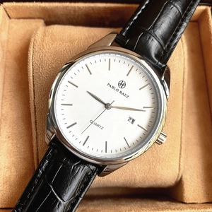 Detailed close-up of a men's quartz watch with white dial and black leather strap in a gift box